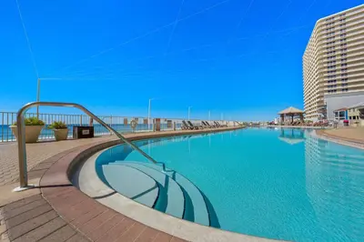 a swimming pool with an umbrella in the middle at Treasure Island #2109 in Panama City Beach