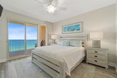 a bedroom with a bed with a view of the ocean at Treasure Island #2007 in Panama City Beach
