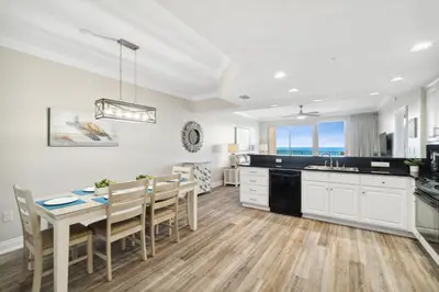 a kitchen and dining room with a table and chairs at Treasure Island #2007 in Panama City Beach