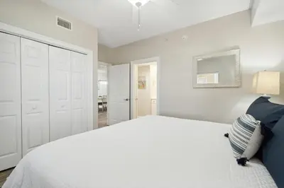 a bedroom with a white bed and a white closet at Treasure Island #2007 in Panama City Beach
