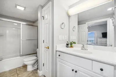 a bathroom with a sink and a toilet and a mirror at Treasure Island #1808 in Panama City Beach