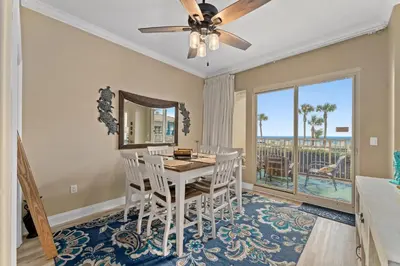 a dining room with a table and chairs and a ceiling fan at Gulf Crest #0106 in Panama City Beach