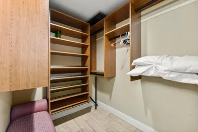 a walk in closet with a bed and a purple chair at Treasure Island #1710 in Panama City Beach