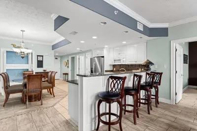 a kitchen and dining room with a table and chairs at Treasure Island #1710 in Panama City Beach