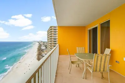 a balcony with a table and chairs and the ocean at Treasure Island #1710 in Panama City Beach