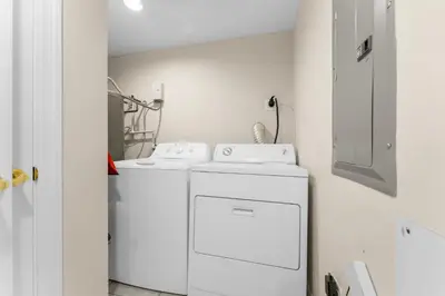 a white laundry room with a washer and dryer at Treasure Island #1609 in Panama City Beach