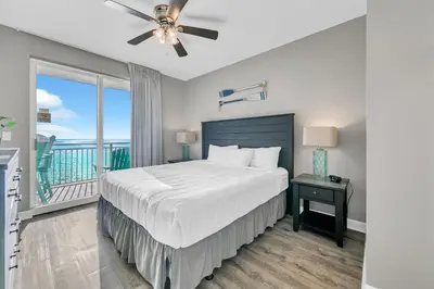 a bedroom with a large bed and a balcony at Sterling Reef 1704 in Panama City Beach