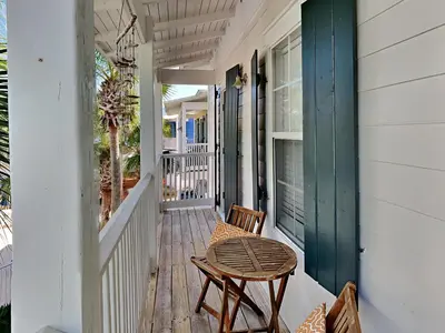 a porch with a table and a chair at Bungalows at Seagrove #149 - Three Little Birds Bungalow 30A in Seagrove Beach