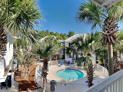 a view of a swimming pool with palm trees at Bungalows at Seagrove #149 - Three Little Birds Bungalow 30A in Seagrove Beach