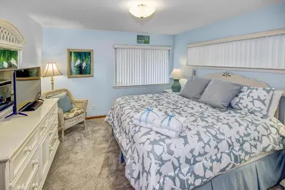 a bedroom with a bed and a flat screen tv at GULF FRONT 3BD/2BA Home with private beach access! in Panama City Beach