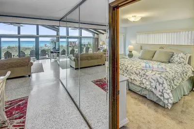 a bedroom with a bed and a living room at GULF FRONT 3BD/2BA Home with private beach access! in Panama City Beach