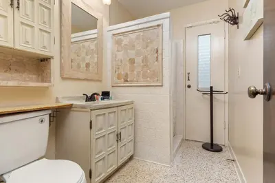 a bathroom with a toilet and a sink and a shower at GULF FRONT 3BD/2BA Home with private beach access! in Panama City Beach