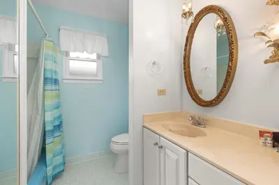 a bathroom with a sink and a mirror and a toilet at GULF FRONT 3BD/2BA Home with private beach access! in Panama City Beach