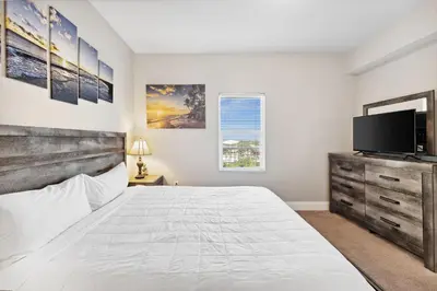 a bedroom with a large bed and a flat screen tv at OCEAN VIEW 10th floor condo at the Laketown Wharf 1004 in Panama City Beach