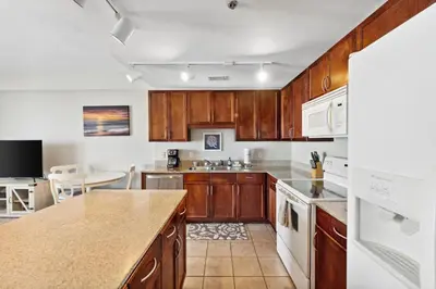 a kitchen with wooden cabinets and a counter top at OCEAN VIEW 10th floor condo at the Laketown Wharf 1004 in Panama City Beach