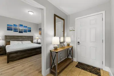 a bedroom with a bed and a table and a door at OCEAN VIEW 10th floor condo at the Laketown Wharf 1004 in Panama City Beach