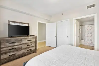 a bedroom with a bed and a flat screen tv at OCEAN VIEW 10th floor condo at the Laketown Wharf 1004 in Panama City Beach