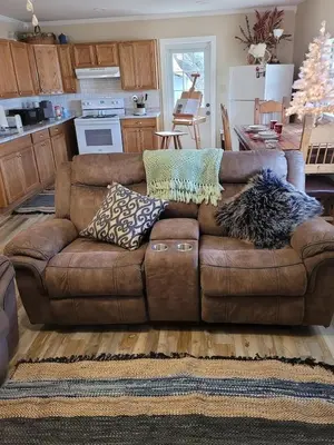 a living room with a brown couch with pillows on it at Historic GWALTNEY HOUSE-Cottage at St Andrew's Bay in Panama City