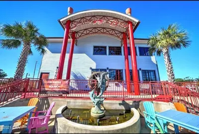a fountain in front of a building with palm trees at Historic GWALTNEY HOUSE-Cottage at St Andrew's Bay in Panama City