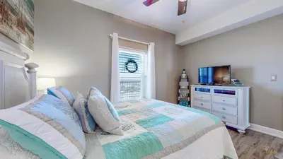 a bedroom with a bed with a window and a dresser at Huge Balcony - Beachfront - Renovated - FLPCB87 in Panama City Beach