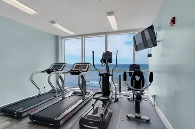 a gym with cardio machines and a large window at Huge Balcony - Beachfront - Renovated - FLPCB87 in Panama City Beach