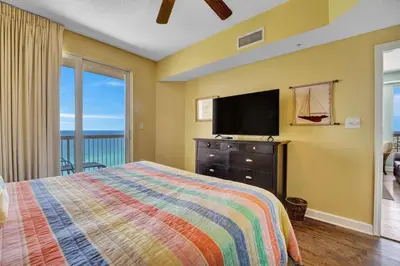 a bedroom with a bed and a flat screen tv at Seychelles 1609 in Panama City Beach