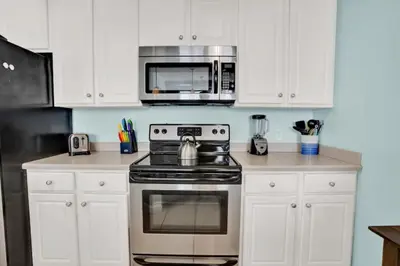 a kitchen with a stove and a microwave at Seychelles 1609 in Panama City Beach