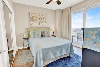 a bedroom with a bed and a large window at Seychelles 1609 in Panama City Beach