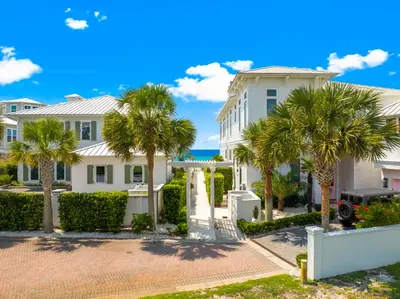 a large white house with palm trees at 30A Sea View Villas by Panhandle Getaways in Santa Rosa Beach
