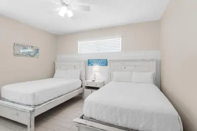 a bedroom with two beds and a ceiling fan at Golden Shores in Panama City Beach