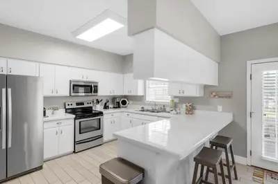 a kitchen with white cabinets and a white counter top at Golden Shores in Panama City Beach