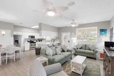 a large living room with a couch and a kitchen at Golden Shores in Panama City Beach