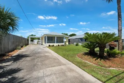 a house with a palm tree and a driveway at Golden Shores in Panama City Beach
