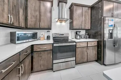 a kitchen with wooden cabinets and stainless steel appliances at Rustic Oasis in Panama City Beach