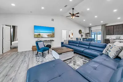 a living room with a blue couch and a table at Rustic Oasis in Panama City Beach