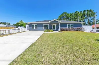 a blue house with a white fence at Rustic Oasis in Panama City Beach