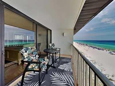 a balcony with two chairs and a table and the beach at Edgewater Leeward #603 in Panama City Beach