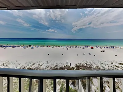 a view from the balcony of a beach with umbrellas at Edgewater Leeward #603 in Panama City Beach