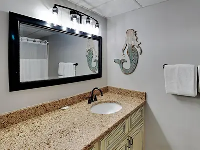 a bathroom with a sink and a mirror at Edgewater Leeward #603 in Panama City Beach