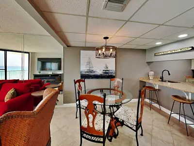 a living room with a red couch and a table at Edgewater Leeward #603 in Panama City Beach