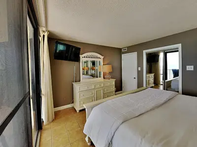 a bedroom with a bed and a dresser and a television at Edgewater Leeward #603 in Panama City Beach