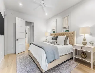 a white bedroom with a bed and a white door at Anchored on 30A in Santa Rosa Beach