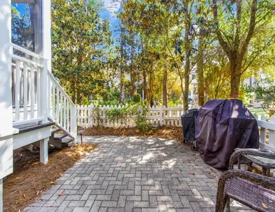 a patio with a white fence and a bench at Anchored on 30A in Santa Rosa Beach
