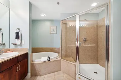 a bathroom with a shower and a tub and a sink at Laketown Wharf #124 by Nautical Properties in Panama City Beach