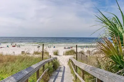 a path to the beach with people on the beach at Sandcastles and Sunshine - Gulf Highlands Beach Resort in Panama City Beach