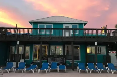 a house with blue chairs on the beach at Sandcastles and Sunshine - Gulf Highlands Beach Resort in Panama City Beach