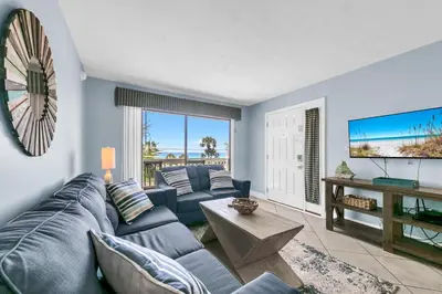 a living room with a blue couch and a tv at Endless Summer A21 in Panama City Beach