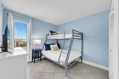 a bedroom with a bunk bed and blue walls at Endless Summer A21 in Panama City Beach