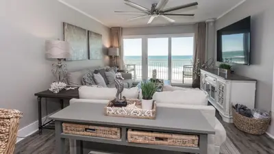 a living room with a couch and a table at 5-STAR BEACHFRONT D505 - Total Remodel - Nov & Dec Snowbirds Welcome! in Panama City Beach