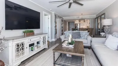 a living room with a large flat screen tv at 5-STAR BEACHFRONT D505 - Total Remodel - Nov & Dec Snowbirds Welcome! in Panama City Beach